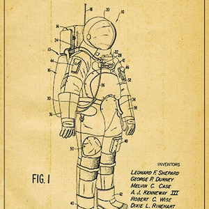 May include: A black and white line drawing of a space suit patent. The patent is titled "Space Suit" and includes the inventors' names and the patent number 3,751,727. The drawing shows a detailed illustration of a space suit with various components labeled with numbers.