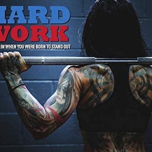 May include: A motivational poster with the words "HARD WORK" in red and blue letters. The poster features a person with tattoos lifting a barbell. The text below the words reads "Why fit in when you were born to stand out."