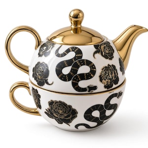 Könnte beinhalten: Ein weißes Keramik-Teeservice für eine Person, bestehend aus einer Teekanne, die auf einer Teetasse gestapelt ist. Das Set ist mit schwarzen Schlangen und Blumenmustern verziert und mit einem glänzenden Goldgriff, Ausguss und Rand versehen.