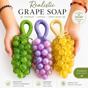Puede incluir: Tres jabones artesanales con forma de uva en verde, morado y amarillo. Cada jabón tiene un asa en forma de lazo y lo sostiene una persona. Los jabones están etiquetados como "Realistic Grape Soap" y están hechos con ingredientes naturales. La imagen también dice "Hecho a mano con amor" y "Regalo perfecto para cualquier ocasión."