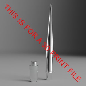 May include: A silver metal spike with a pointed tip and a cylindrical base. The spike is standing upright on a gray surface.