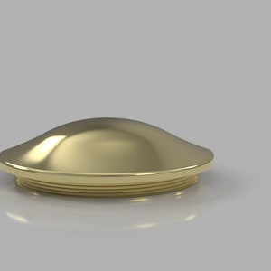 May include: A gold-colored metal cap with a rounded top and a slightly flared base. The cap has a smooth, polished finish.