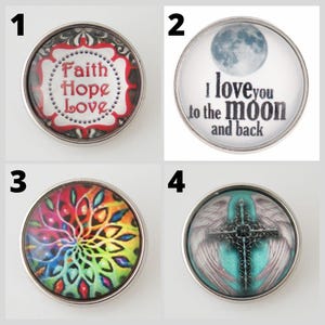 May include: Four round snap jewelry charms with silver-colored metal rims. The charms feature various designs: "Faith Hope Love" text, a moon with text, a colorful mandala, and a cross with wings.