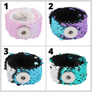 May include: Four reversible sequin bracelets with snap closures. The bracelets are in pink and white, purple and blue, black and blue, and white and teal.