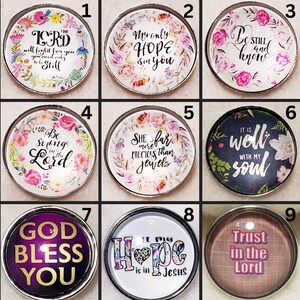 May include: A collection of nine round, decorative snap buttons with inspirational quotes and floral designs. The buttons feature phrases like "The Lord will fight for you," "My only hope is in you," and "Trust in the Lord."
