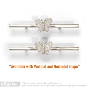 May include: Two silver butterfly drawer pulls with a horizontal bar. The butterfly design is raised and detailed. "Available with Vertical and Horizotal shape" is written below the pulls.