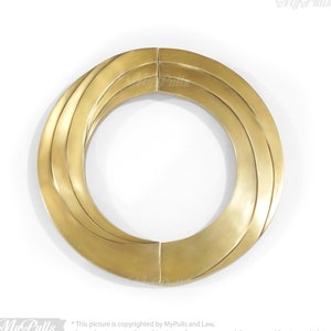 May include: A gold-toned, round, decorative door pull with a concentric circle design.