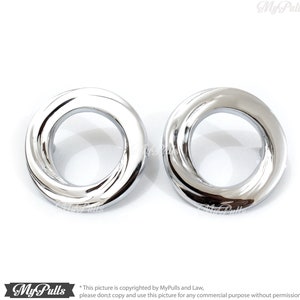 Pode incluir: Dois anéis de metal prateados com um design retorcido. Os anéis são redondos e têm um acabamento liso e polido.