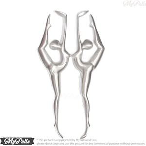 Puede incluir: Dos esculturas metálicas de color plateado de bailarines en una pose de flexión hacia atrás. Las esculturas se enfrentan y están unidas de las manos.