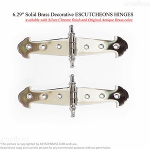 May include: Two solid brass decorative escutcheon hinges with a silver chrome finish. Each hinge is 6.29 inches long and features a decorative design. The text on the image says "Solid Brass Decorative ESCUTCHEONS HINGES".