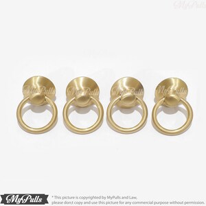 Puede incluir: Cuatro tiradores de armario de anillo de color dorado con base redonda. Los tiradores miden aproximadamente 2,5 cm de di&aacute;metro.