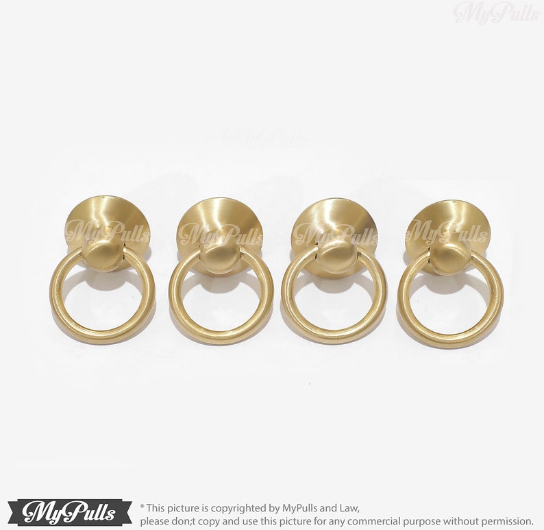 Puede incluir: Cuatro tiradores de armario de anillo de color dorado con base redonda. Los tiradores miden aproximadamente 2,5 cm de di&aacute;metro.