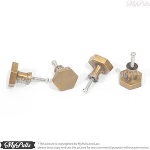 Puede incluir: Cuatro pomos hexagonales de armario de lat&oacute;n antiguo con tornillos. Los pomos tienen un acabado ligeramente desgastado.