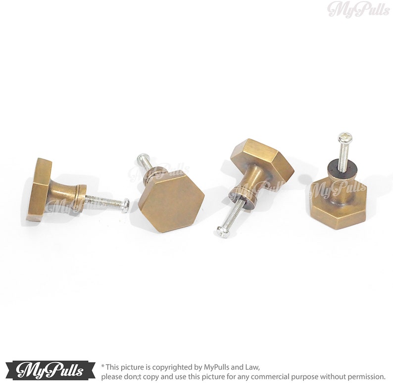 Puede incluir: Cuatro pomos hexagonales de armario de lat&oacute;n antiguo con tornillos. Los pomos tienen un acabado ligeramente desgastado.