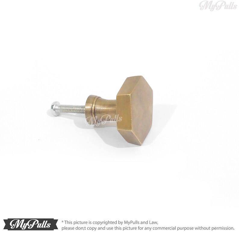 Puede incluir: Un pomo de armario hexagonal de lat&oacute;n con un tornillo plateado.