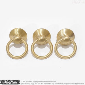 Puede incluir: Tres tiradores de anillo de color dorado con base redonda. Los tiradores est&aacute;n dise&ntilde;ados para usarse en armarios, cajones o puertas.
