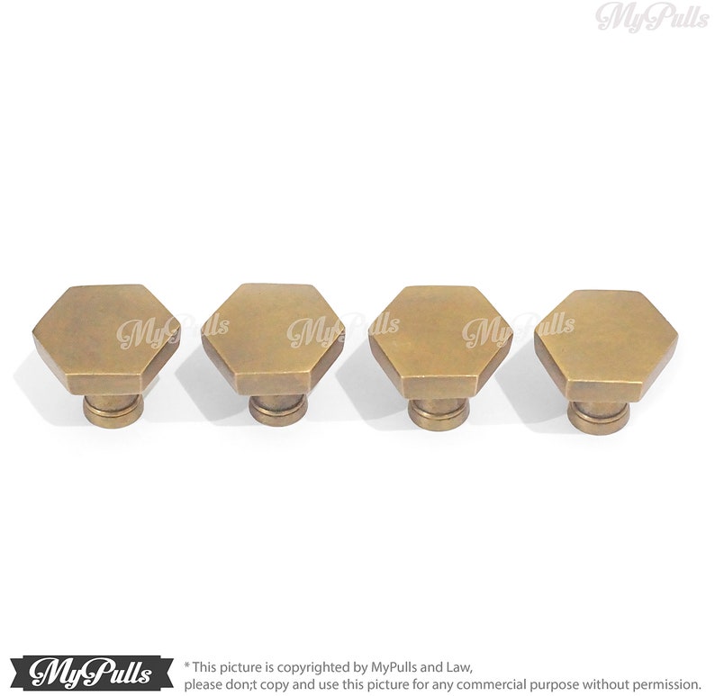 Puede incluir: Cuatro pomos hexagonales de armario de lat&oacute;n antiguo con una parte superior ligeramente redondeada.