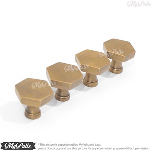 Puede incluir: Cuatro pomos hexagonales de armario de lat&oacute;n antiguo. Los pomos est&aacute;n dispuestos en fila, con el pomo m&aacute;s grande en la parte posterior y el pomo m&aacute;s peque&ntilde;o en la parte delantera.