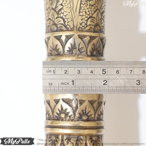 Puede incluir: Primer plano de un bast&oacute;n de metal dorado con intrincados dise&ntilde;os florales. Una regla se coloca junto al bast&oacute;n, mostrando que tiene 12,7 cm de largo.