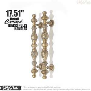 May include: A pair of 17.51 inch antique brass door pulls with intricate carved details. The pulls are made of solid brass and have a polished finish.
