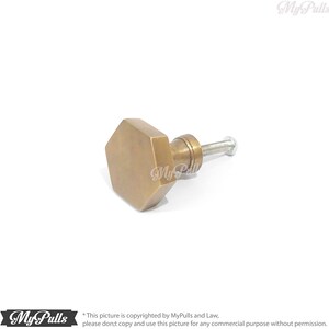 Puede incluir: Un pomo de armario hexagonal de lat&oacute;n con un tornillo. El pomo tiene un acabado ligeramente envejecido, antiguo.