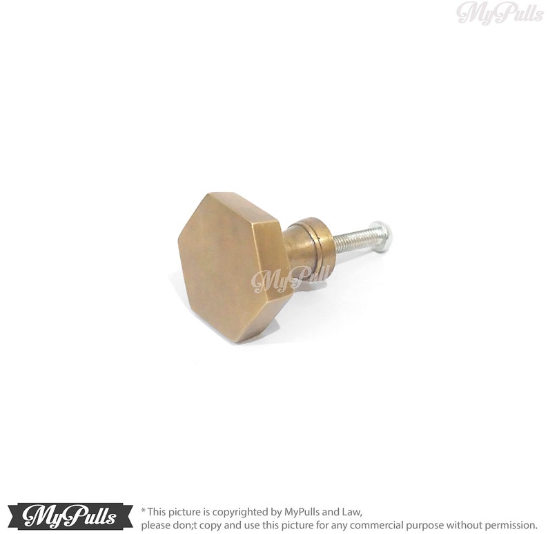 Puede incluir: Un pomo de armario hexagonal de lat&oacute;n con un tornillo. El pomo tiene un acabado ligeramente envejecido, antiguo.