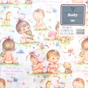 Op de afbeelding: Een roze en wit babycadeaupapier met een herhalend patroon van baby's, teddyberen en speelgoed. De tekst "Baby girls are softness and sweetness and love." is op het cadeaupapier gedrukt. De tekst "Baby Gift Wrap 98&cent;" is op een grijs label gedrukt.