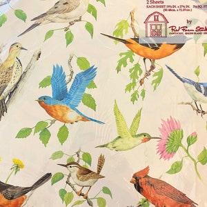 May include: Gift wrap featuring a colourful pattern of birds and flowers on a white background. The text "Giftwrap" is printed in the top right corner, along with the brand name "Red Farm Studio" and the location "Pawtucket, Rhode Island 02861".