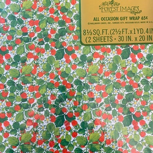 May include: A sheet of red and green strawberry patterned gift wrap with the text "Hallmark Forest Images All Occasion Gift Wrap 65&cent; Hallmark Cards, Inc. Kansas City, Missouri 64141 Made in U.S.A. 8 1/3 sq. ft. (2 1/2 ft. x 1 yd. 4 in. (2 sheets 30 in. x 20 in."