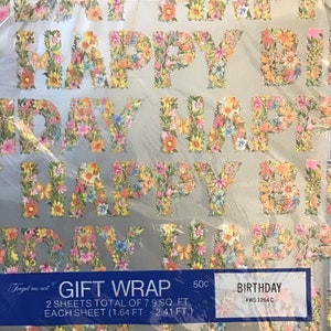 May include: A roll of floral patterned gift wrap with the words "Happy Birthday" in large letters. The wrap is silver with a floral design in pink, yellow, and green. The text on the label reads "Forget me not Gift Wrap 2 sheets total of 7.9 sq. ft. Each sheet (1.64 ft. x 2.41 ft.) 50c Birthday FWS 1264 C".