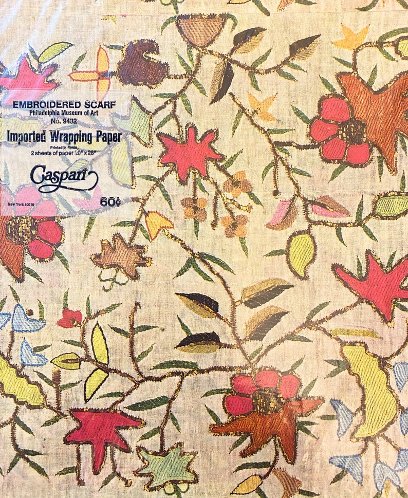 May include: A vintage wrapping paper design featuring a floral pattern with red, yellow, and green flowers on a cream background. The paper is labelled "Embroidered Scarf" and "Imported Wrapping Paper" with the text "Gaspari" and "60&cent;".
