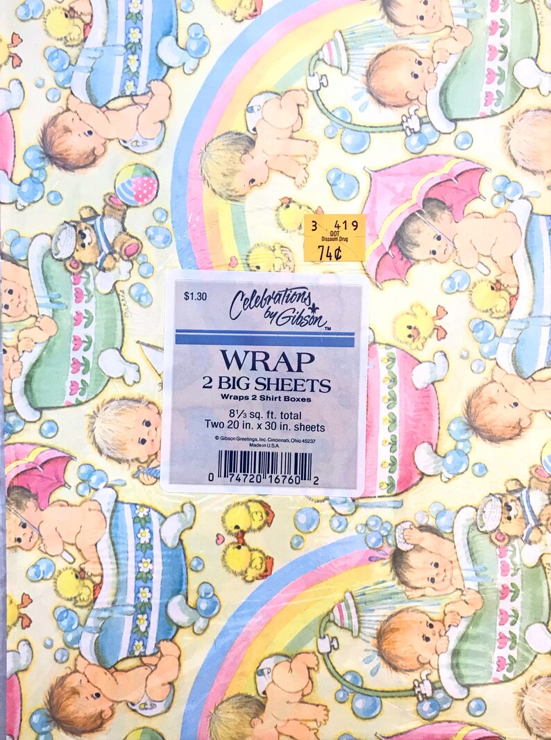 Op de afbeelding: Een geel en roze cadeaupapier met een regenboogontwerp en een patroon van baby's in badkuipen. Het papier is gelabeld "Celebrations by Gibson" en "Wrap 2 Big Sheets". Het papier is 8 1/3 vierkante voet en bevat twee vellen van 20 x 30 inch.