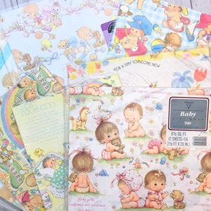 Op de afbeelding: Een set baby-thema cadeaupapier met verschillende ontwerpen met baby's, dieren en bloemen. Het cadeaupapier is wit met roze, blauwe en gele accenten. De tekst op het cadeaupapier luidt "Baby girls are softness and sweetness and love." en "For a tiny someone new".