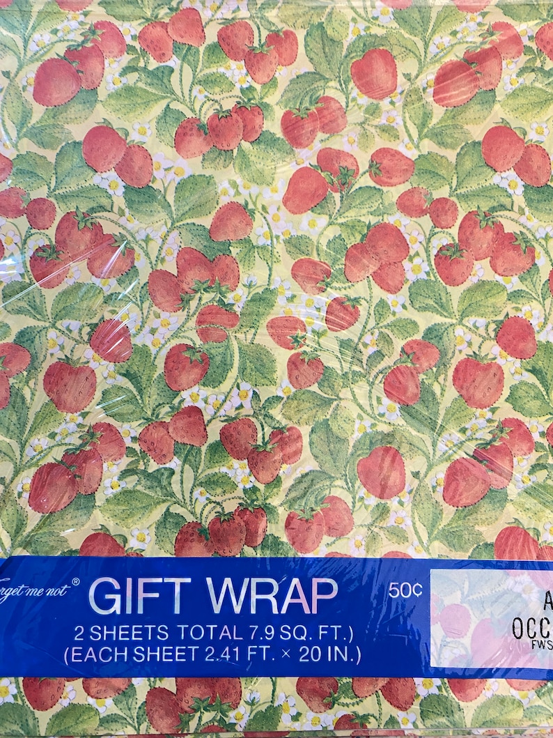 May include: A roll of gift wrap with a strawberry pattern on a yellow background. The text on the label reads "Forget me not GIFT WRAP 2 SHEETS TOTAL 7.9 SQ. FT. (EACH SHEET 2.41 FT. x 20 IN.) 50c".