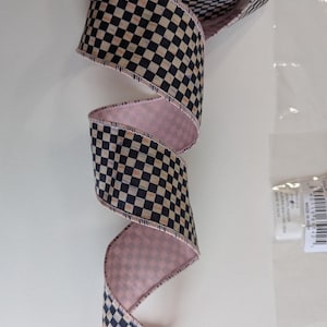 May include: A black and cream checkered ribbon with a pink backing. The ribbon is folded and curled, showing the pattern and the pink backing.