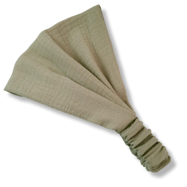 May include: A light green fabric headband with a gathered end.