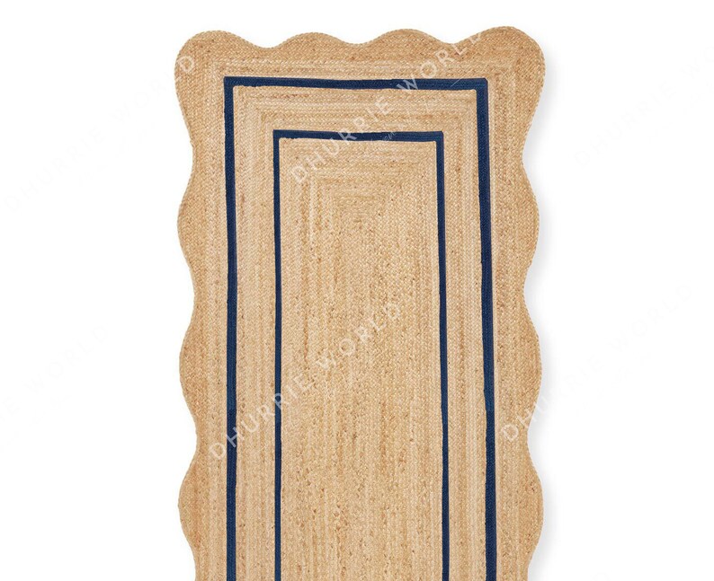 May include: A natural fiber rug with a scalloped edge and a double border of navy blue trim.