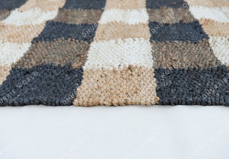 May include: A checkered rug with black, white, and brown squares. The rug is made of a woven material and has a textured surface.