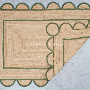 May include: A natural fiber rug with a green scalloped border. The rug is folded in half, revealing a second layer of green trim.