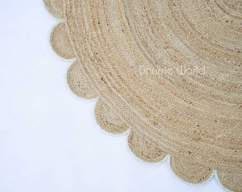 May include: A round jute rug with a scalloped edge. The rug is made of natural fibers and has a light brown color.