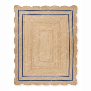 May include: A natural fiber rug with a scalloped edge and a double blue border. The rug is made of jute and has a natural, earthy color.