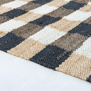 May include: A checkered jute rug with black, white, and brown squares. The rug is woven with a natural fiber and has a rustic look.