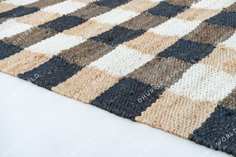 May include: A checkered jute rug with black, white, and brown squares. The rug is woven with a natural fiber and has a rustic look.