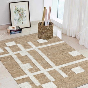 May include: A beige and white geometric patterned jute rug with a white background and beige lines. The rug is on a white tiled floor in a room with a white wall and a wicker basket.