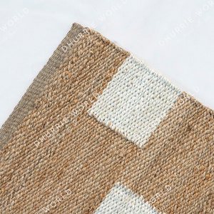 May include: A natural fiber rug with a striped pattern in beige and white. The rug is woven with a textured, slightly rough surface.