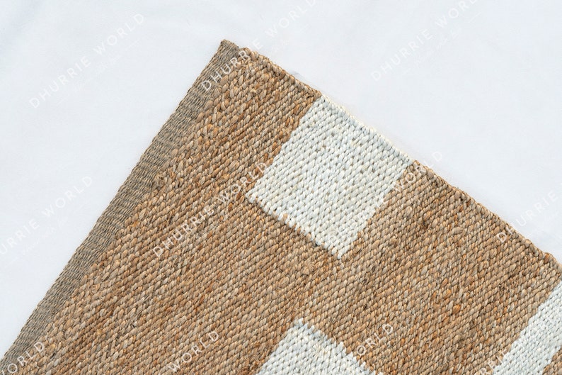 May include: A natural fiber rug with a striped pattern in beige and white. The rug is woven with a textured, slightly rough surface.