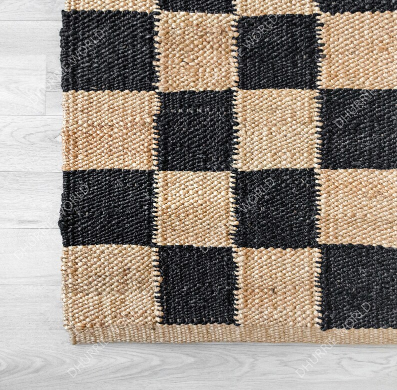 May include: A black and beige checkered jute rug. The rug is made of natural fibers and has a woven texture.