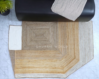 May include: A geometric jute rug with a white border and a central square design. The rug has a natural, earthy color palette and is perfect for adding a touch of texture and warmth to any room.