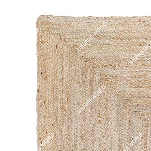 May include: A square natural jute rug with a woven pattern. The rug has a light beige color and a slightly rough texture.