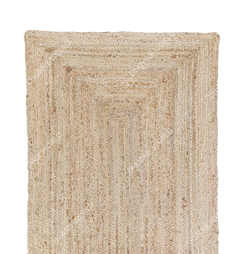 May include: A natural fiber rug with a woven design. The rug is made of jute and has a light brown color.